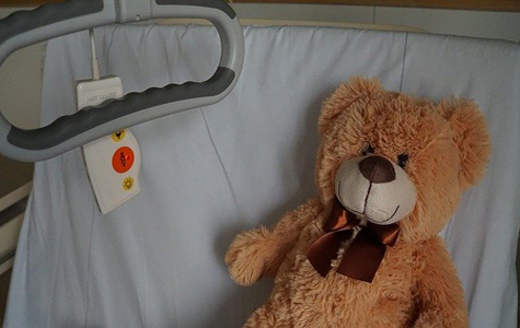 Sick teddy bear in a hospital bed